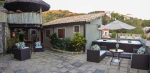 un patio con bañera de hidromasaje y un edificio en Pousada Juannas Buzios, en Búzios