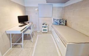 ein Zimmer mit einem Schreibtisch mit Computer und einem Bett in der Unterkunft Casa Caracoles en Costa Teguise in Costa Teguise