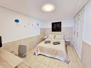 ein Schlafzimmer mit einem Bett, einem Tisch und einem Stuhl in der Unterkunft Casa Caracoles en Costa Teguise in Costa Teguise
