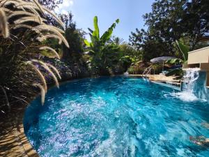 a pool with a waterfall in a backyard at A historic STONE VILLA with private garden, terrace and private pool just for you in Kliru