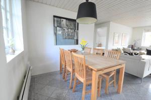 a dining room with a wooden table and chairs at 10849-Ulfborg-Dommersovej-17 in Øby