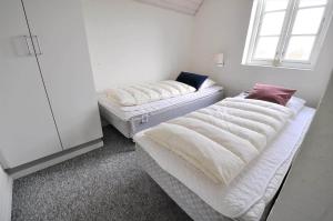 two beds sitting in a room with a window at 10849-Ulfborg-Dommersovej-17 in Øby