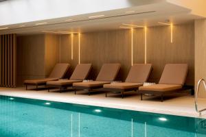 a waiting room with chairs and a pool at Yalarent Amazing apartments U360 Complex Eilat in Eilat