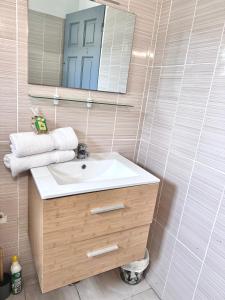 a bathroom with a sink and a mirror at Ameli'ber in Sainte-Rose +12 photos