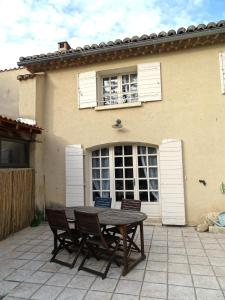 a table and chairs in front of a house at Le Gite au coin du feu in Cabannes