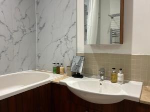 a bathroom with a sink and a bath tub at 4-Bedroom Apartment – Sleeps 7 – Paddington – Quiet Area in London +25 photos