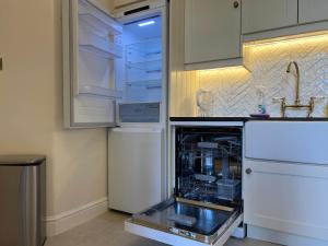 an empty refrigerator with its door open in a kitchen at 4-Bedroom Apartment – Sleeps 7 – Paddington – Quiet Area in London