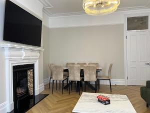 a dining room with a table and a fireplace at 4-Bedroom Apartment – Sleeps 7 – Paddington – Quiet Area in London