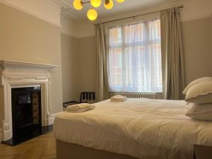 a bedroom with a bed with a fireplace and a window at 4-Bedroom Apartment – Sleeps 7 – Paddington – Quiet Area in London