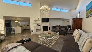 a living room with a couch and a table at Waterfront Villa Retreat, Langebaan in Langebaan