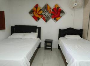 a bedroom with two beds and a clock on the wall at Casa S&J in Mompos