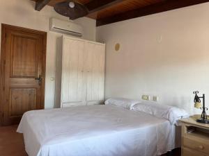 a bedroom with a white bed and a wooden door at Casa María in Estación de Cártama +11 photos