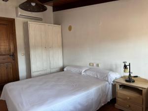 a bedroom with a white bed and a night stand at Casa María in Estación de Cártama