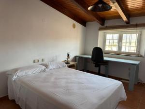 a bedroom with a bed and a desk and a chair at Casa María in Estación de Cártama