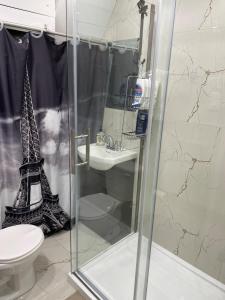 a bathroom with a shower with a toilet and the eiffel tower at Private apartment-separate in Pincourt +29 photos