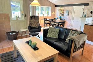 un soggiorno con un divano nero e un tavolo di 40893-Ulfborg-Skindbjergvej-393 a Fjand Gårde