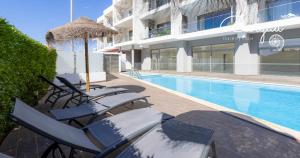 ブルガウにあるBurgau Charming House Loftの建物の隣に椅子とパラソルのあるプール