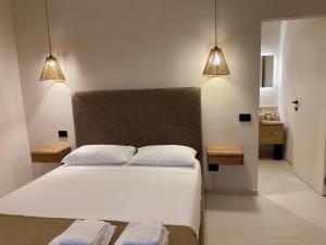 Case FortullinoにあるRoc Villa Castiglioncello - Private Villa with 2 Beaches and Parkの2つのライトが付いた白いベッドのある寝室