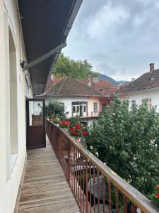 a balcony with a door and flowers on a house at Centru Vechi Brasov in Braşov