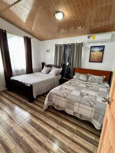 a bedroom with two beds and a window at Vista al Volcán Tenorio y Montaña in San Rafael