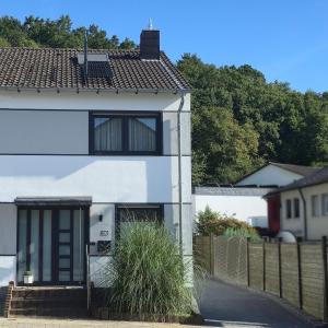 a white house with a gate and a fence at Ferienhaus "Auberge Jolie" in Aachen