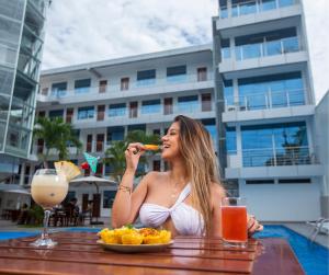 a woman sitting at a table with a plate of food at Rio Cumbaza Hotel in Tarapoto