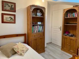 a bedroom with a bed and a book shelf at Le Retro & Pierres Dorées in Le Bois-dʼOingt