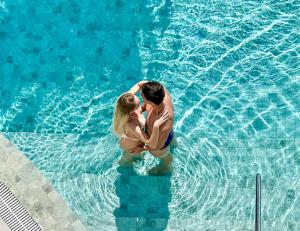 a man and woman standing in a swimming pool at Palace Praia Hotel in Florianópolis