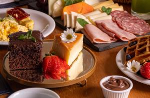a table topped with different types of food on plates at Palace Praia Hotel in Florianópolis +88 photos