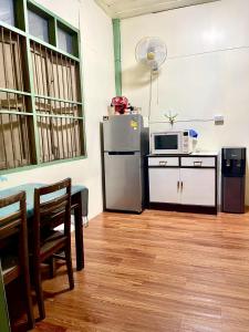 a kitchen with a refrigerator and a table and a microwave at BaanKhamSuk in Chiang Mai