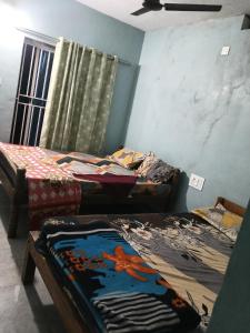 a room with three beds and a window at Nagamma guest house in Gokarna