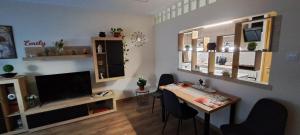 een woonkamer met een tafel en een televisie bij Emily Apartman Salgótarján in Salgótarján