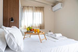 a bed with a table with fruit and drinks on it at Eagles Nest Panoramic SeaView Apartment in Thérissos