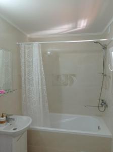 a white bathroom with a shower and a sink at Файна садиба in Volovets +19 photos