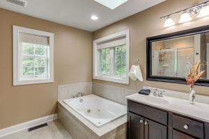 a bathroom with a tub and a sink and two windows at Game Room and Hot Tub Big Fun in Ellicottville in Ellicottville +32 photos