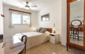 a bedroom with a bed and a table and a mirror at Amazing Apartment In Altea With Kitchen in Altea
