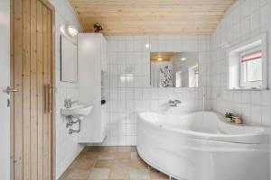 um banheiro branco com banheira e pia em 40812-Ulfborg-Helmklit-214 em Fjand Gårde mais 18 fotografias