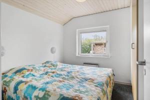 um quarto com uma cama e uma janela em 40812-Ulfborg-Helmklit-214 em Fjand Gårde