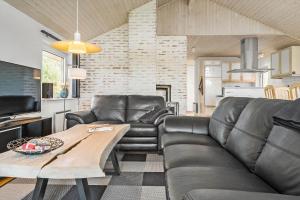 uma sala de estar com um sofá de couro e uma mesa em 40812-Ulfborg-Helmklit-214 em Fjand Gårde