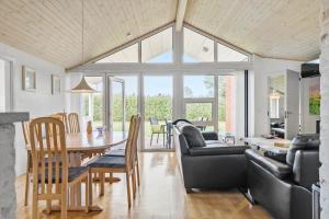 uma sala de jantar e sala de estar com mesa e cadeiras em 40812-Ulfborg-Helmklit-214 em Fjand Gårde
