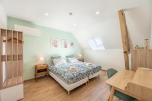 a bedroom with a bed and a table in a room at La grange in Sacy-le-Petit