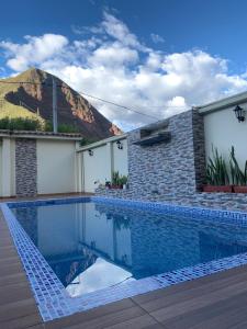a swimming pool in front of a house with a mountain at Casa de Campo en el Valle Sagrado de los Incas - Casa Brisas del Rio Sagrado in Huayllabamba