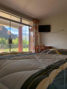 a bedroom with a bed and a large window at Casa de Campo en el Valle Sagrado de los Incas - Casa Brisas del Rio Sagrado in Huayllabamba