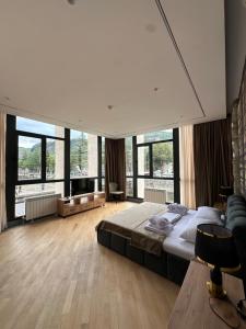 a large bedroom with a large bed and large windows at Hotel Kvirila in Tsinsopʼeli