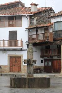 an old house with wooden balconies on top of it at Apartamentos Rurales La Lancha in Aldeanueva de la Vera