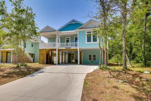 une maison bleue avec un porche et une allée dans l'établissement Coastal North Carolina Retreat Half Mile to Beach, à Île au chêne