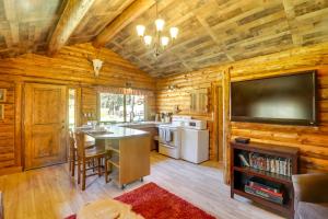 a kitchen with wooden walls and a flat screen tv at West Kootenai Cabin in Amish Country! in Rexford