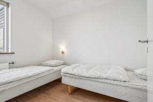 two beds in a white room with a window at 70774-Ulfborg-Skolegade-15-Lejl-5 in Thorsminde