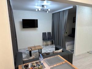 a living room with a couch and a table at Однокомнатная квартира посуточно Люкс in Balqash