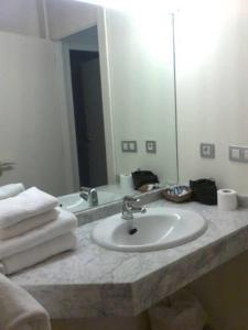 a bathroom counter with a sink and a mirror at Casa de los Beneficiados in Roncesvalles